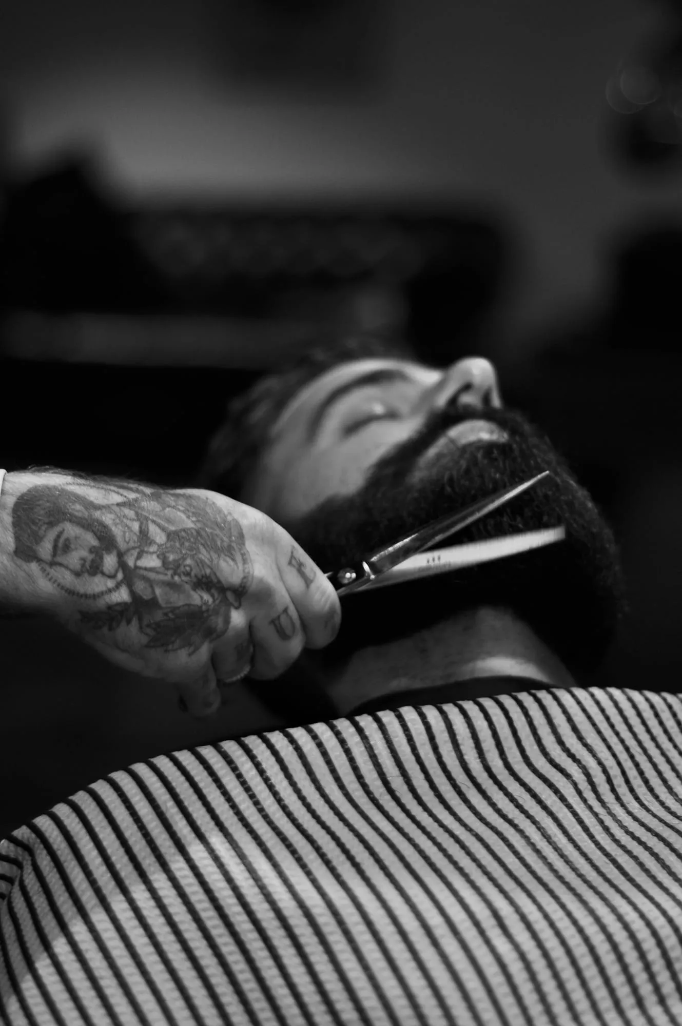 Black and white photo of a beard being trimmed with scissors