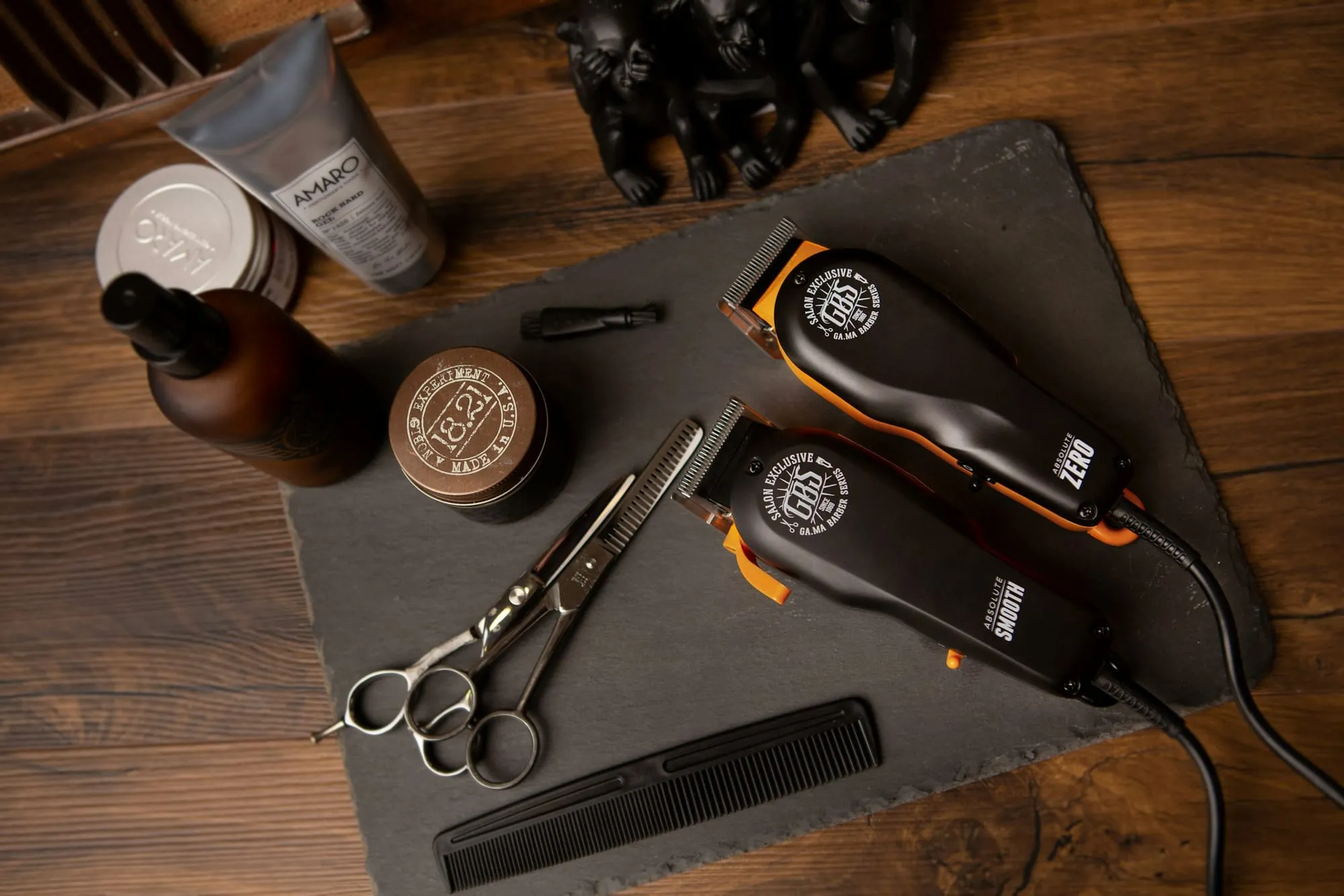 Clippers, scissors and grooming products on a slate board