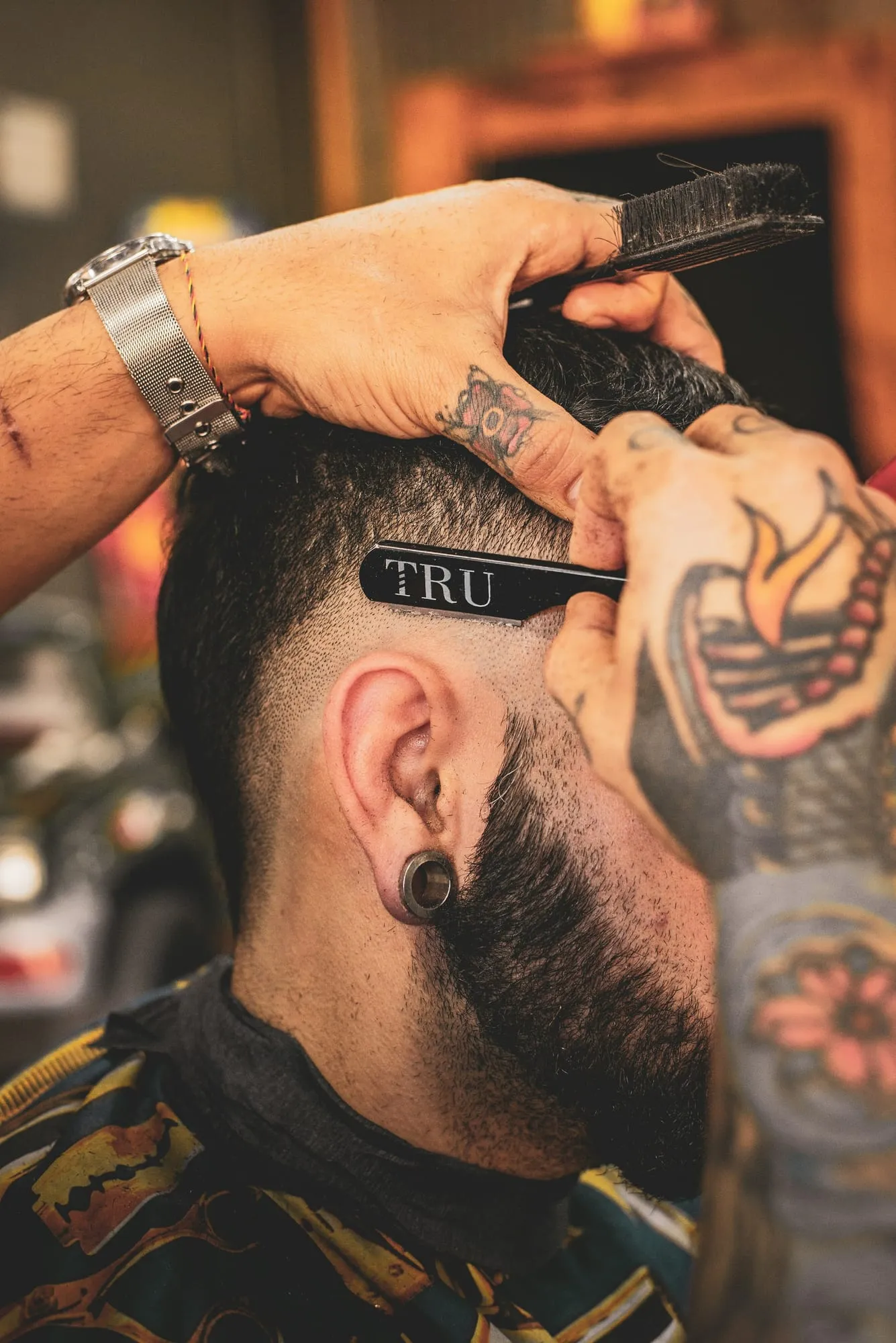 Barber lining up a fade with a straight razor
